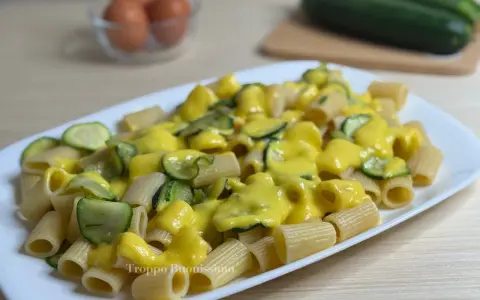 Piatto di rigatoni conditi con una cremosa salsa gialla e zucchine a rondelle, una deliziosa carbonara di zucchine.