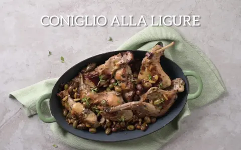 Un saporito coniglio alla ligure, cotto con olive e pinoli, servito in una casseruola verde.