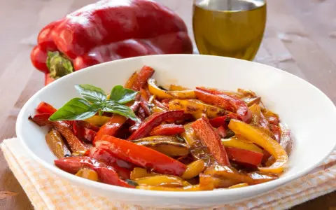 Peperoni in friggitrice ad aria, colorati e succosi, guarniti con basilico fresco.