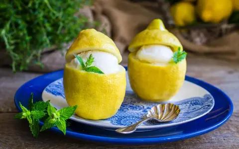 Due deliziosi sorbetti al limone serviti in veri limoni svuotati, guarniti con menta fresca. Un dessert rinfrescante e visivamente accattivante.