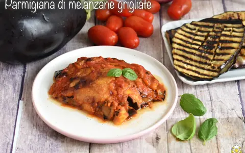 Parmigiana di melanzane grigliate, un piatto saporito con melanzane grigliate, pomodoro e basilico fresco.