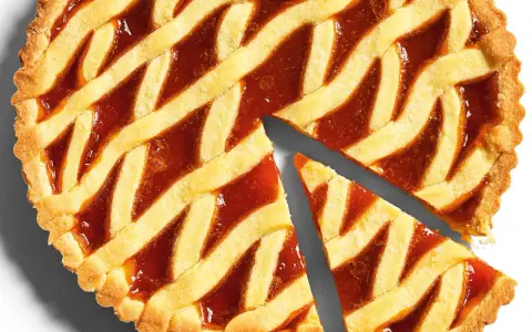 Torta con pasta frolla classica e marmellata, con una fetta tagliata.