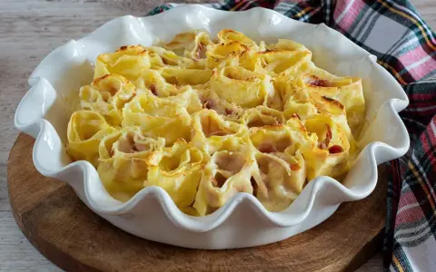 Deliziosi nidi di rondine ripieni di prosciutto e formaggio, cotti al forno in una teglia bianca.