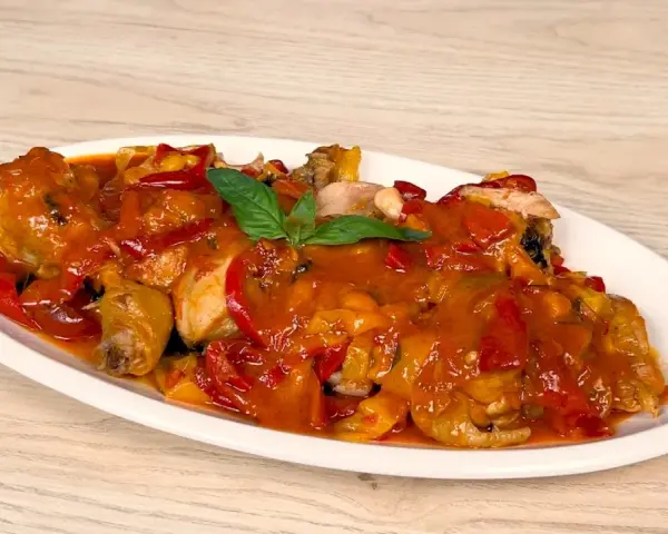 Pollo alla romana succulento, con peperoni rossi e gialli, in un sugo ricco.