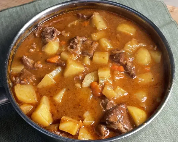 Un invitante spezzatino di manzo con patate e carote in un ricco sugo, pronto per essere gustato.