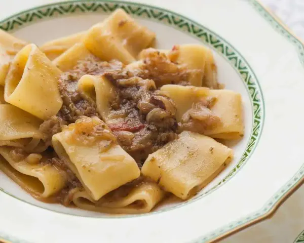 Paccheri alla genovese, un piatto ricco e saporito, con pasta fresca e un sugo di cipolle caramellate e carne.