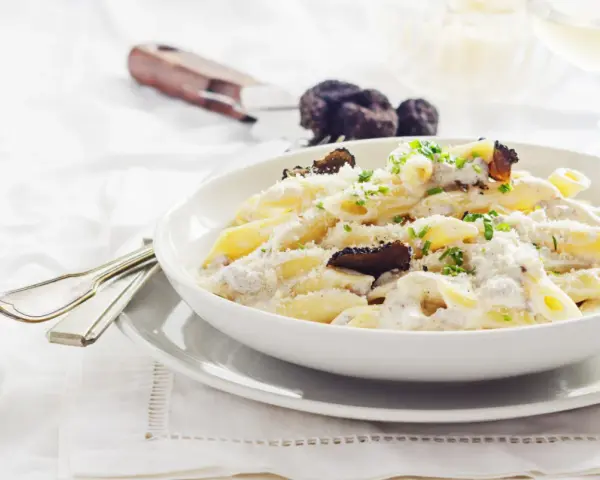 Penne cremose con funghi e tartufo nero, un piatto di pasta alla norcina che invita alla degustazione.