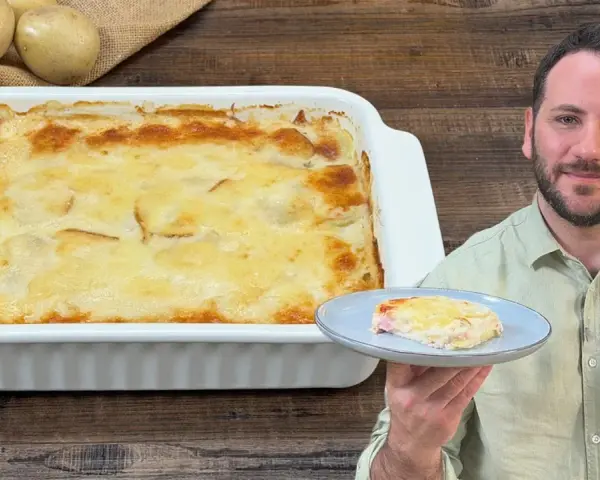 Una teglia fumante di parmigiana di patate, dorata e invitante, con una porzione servita su un piatto.
