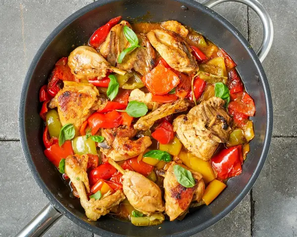 Straccetti di pollo con peperoni rossi e gialli, cotti in padella con basilico fresco.