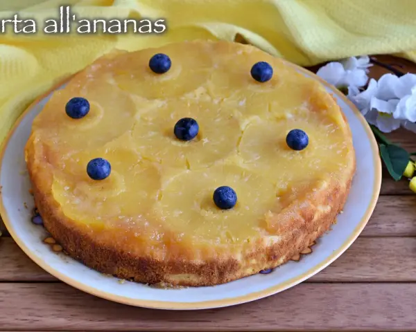 Deliziosa torta rovesciata all'ananas, con fette di ananas caramellate e mirtilli freschi, pronta per essere gustata.