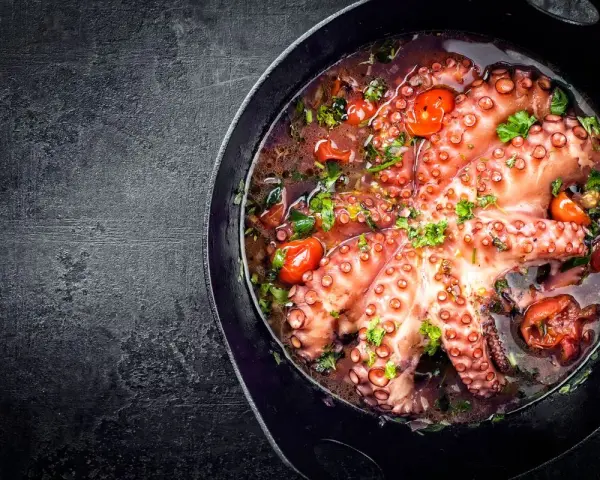 Polpo alla luciana in padella, con pomodorini e prezzemolo. Un piatto succulento e profumato.