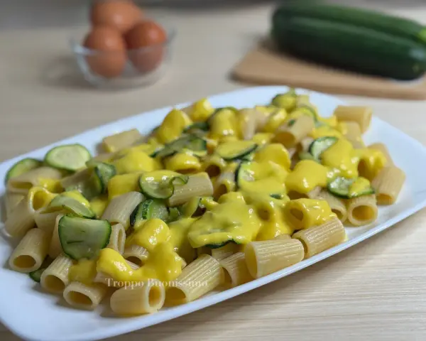 Piatto di rigatoni conditi con una cremosa salsa gialla e zucchine a rondelle, una deliziosa carbonara di zucchine.