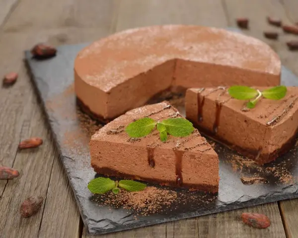 Deliziosa bavarese al cioccolato, cosparsa di cacao e decorata con menta fresca. Due fette sono già state servite.