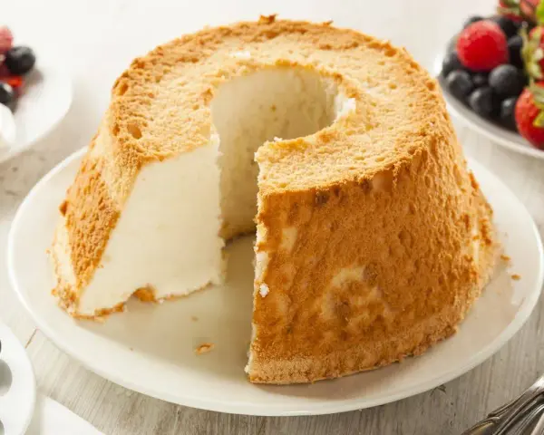 Torta soffice e leggera, un classico tra i dolci con albumi, servita con frutti di bosco freschi.