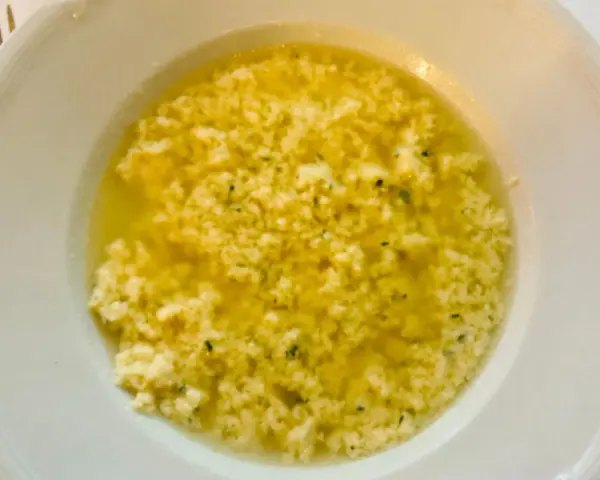 Stracciatella alla romana in una ciotola bianca, un piatto caldo e confortante con uova, parmigiano e prezzemolo.