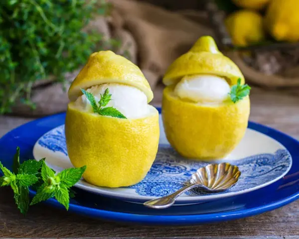 Due deliziosi sorbetti al limone serviti in veri limoni svuotati, guarniti con menta fresca. Un dessert rinfrescante e visivamente accattivante.