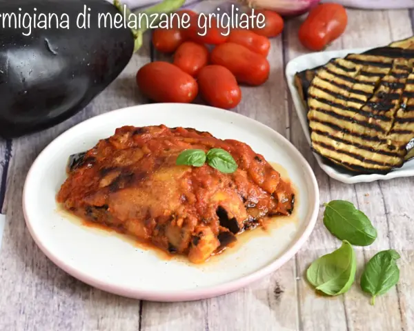 Parmigiana di melanzane grigliate, un piatto saporito con melanzane grigliate, pomodoro e basilico fresco.