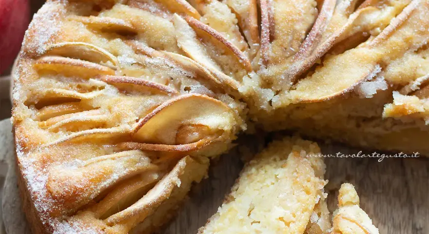 Deliziosa torta di mele senza zucchero, con mele a fettine disposte a raggiera e una spolverata di zucchero a velo.