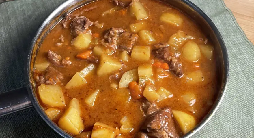 Un invitante spezzatino di manzo con patate e carote in un ricco sugo, pronto per essere gustato.