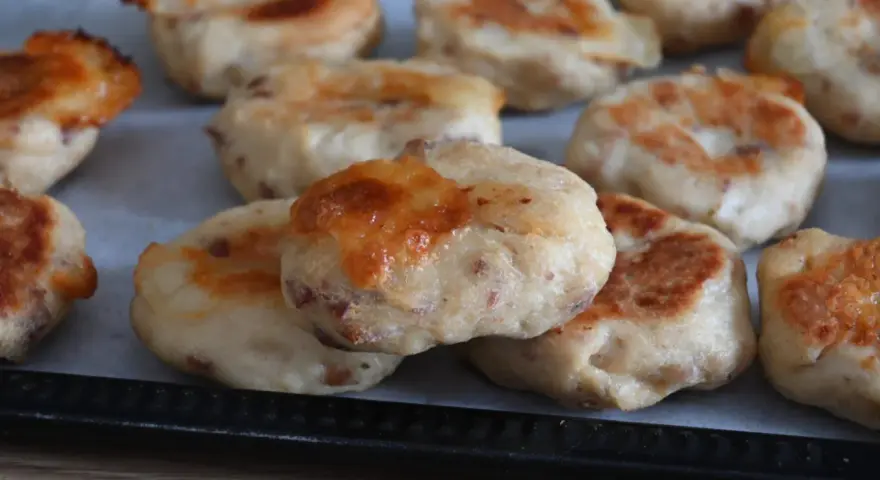 Polpette di pollo dorate e gustose, appena sfornate, con formaggio fuso che cola.