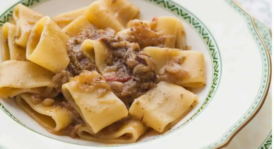 Paccheri alla genovese, un piatto ricco e saporito, con pasta fresca e un sugo di cipolle caramellate e carne.