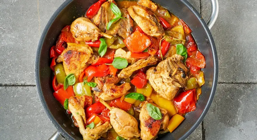 Straccetti di pollo con peperoni rossi e gialli, cotti in padella con basilico fresco.