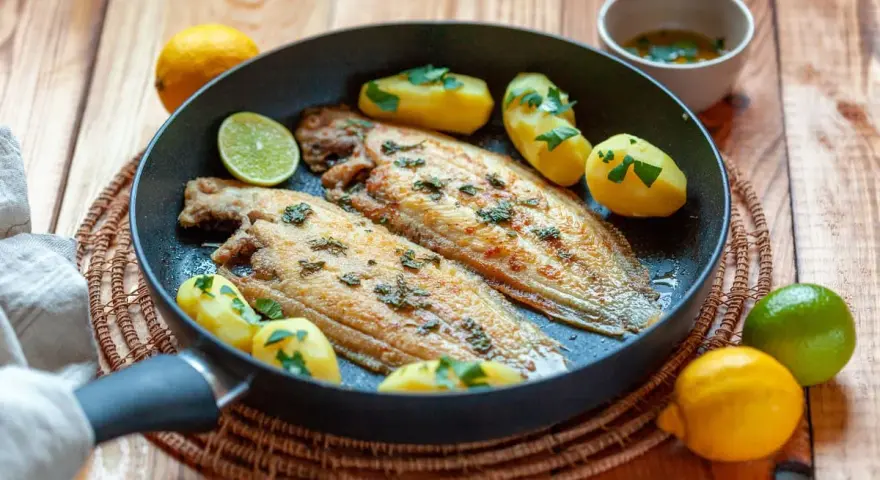 Sogliola alla mugnaia dorata in padella con patate novelle e limone, un piatto semplice e gustoso.