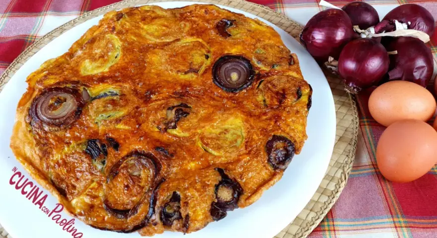 Frittata di pane dorata con cipolle rosse, uova e ingredienti freschi.