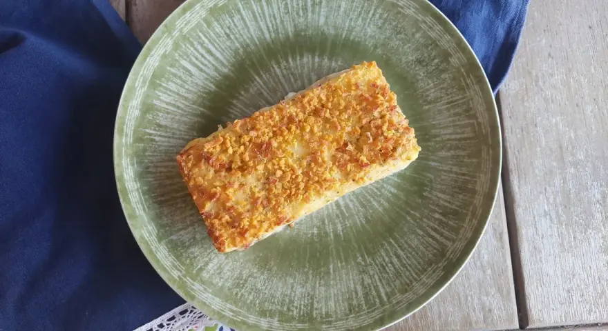 Delizioso merluzzo in friggitrice ad aria, croccante e dorato, servito su un piatto verde.