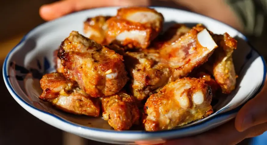 Succulente costine di maiale in friggitrice ad aria, dorate e pronte per essere gustate.