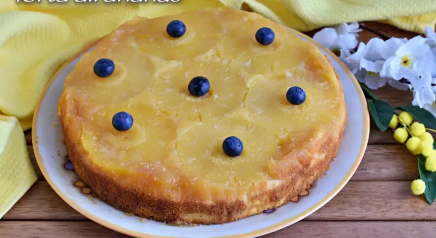 Deliziosa torta rovesciata all'ananas, con fette di ananas caramellate e mirtilli freschi, pronta per essere gustata.