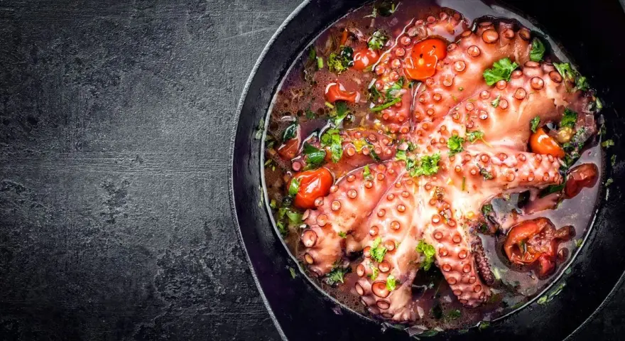 Polpo alla luciana in padella, con pomodorini e prezzemolo. Un piatto succulento e profumato.