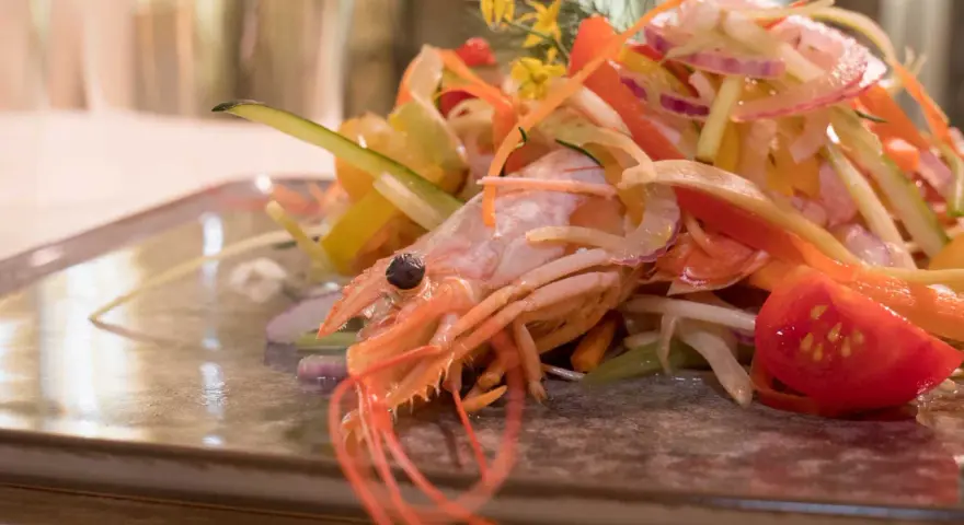 Gambero rosa su letto di verdure fresche, un'elegante catalana di crostacei.