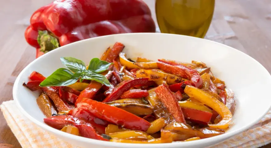Peperoni in friggitrice ad aria, colorati e succosi, guarniti con basilico fresco.