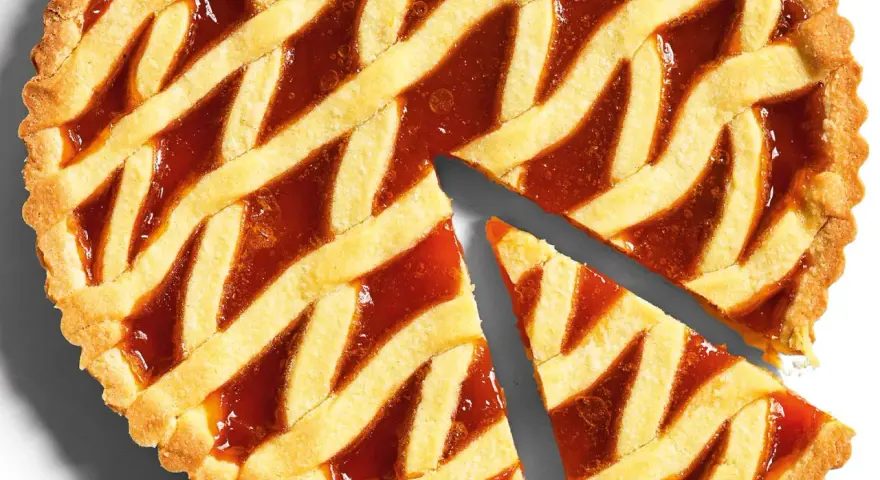 Torta con pasta frolla classica e marmellata, con una fetta tagliata.