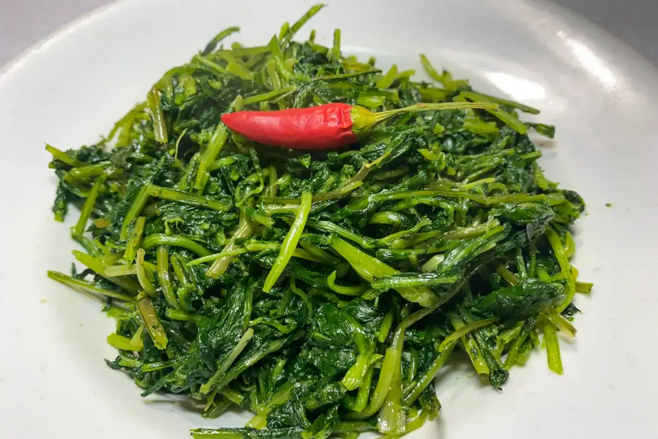 Cicoria in padella, un contorno saporito con un peperoncino rosso che aggiunge un tocco di piccantezza.