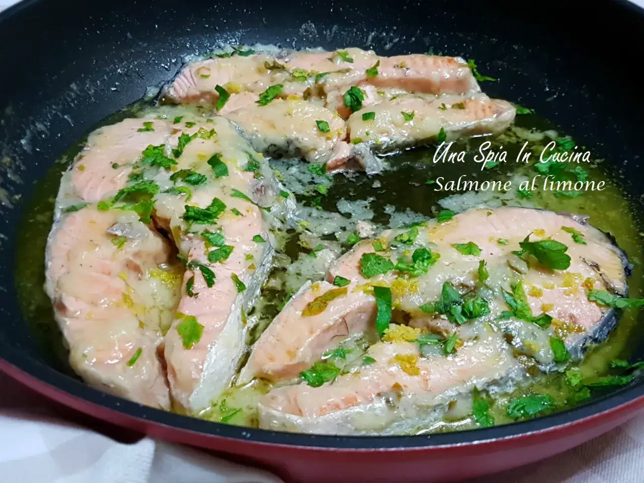 Tranci di salmone in padella, cotti con limone e prezzemolo, profumano di buono.