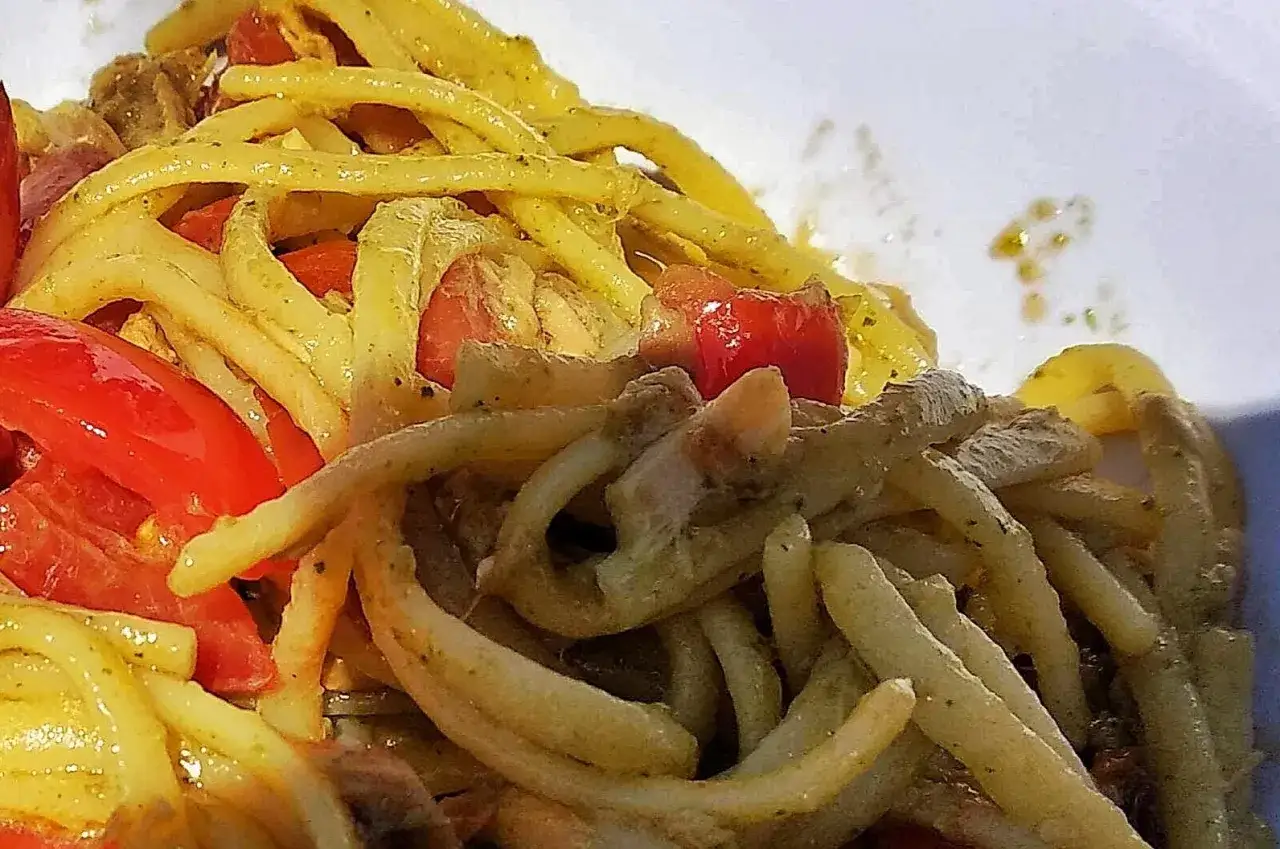 Un primo piatto saporito: pasta alla carlofortina con pomodorini freschi e un condimento verde profumato.
