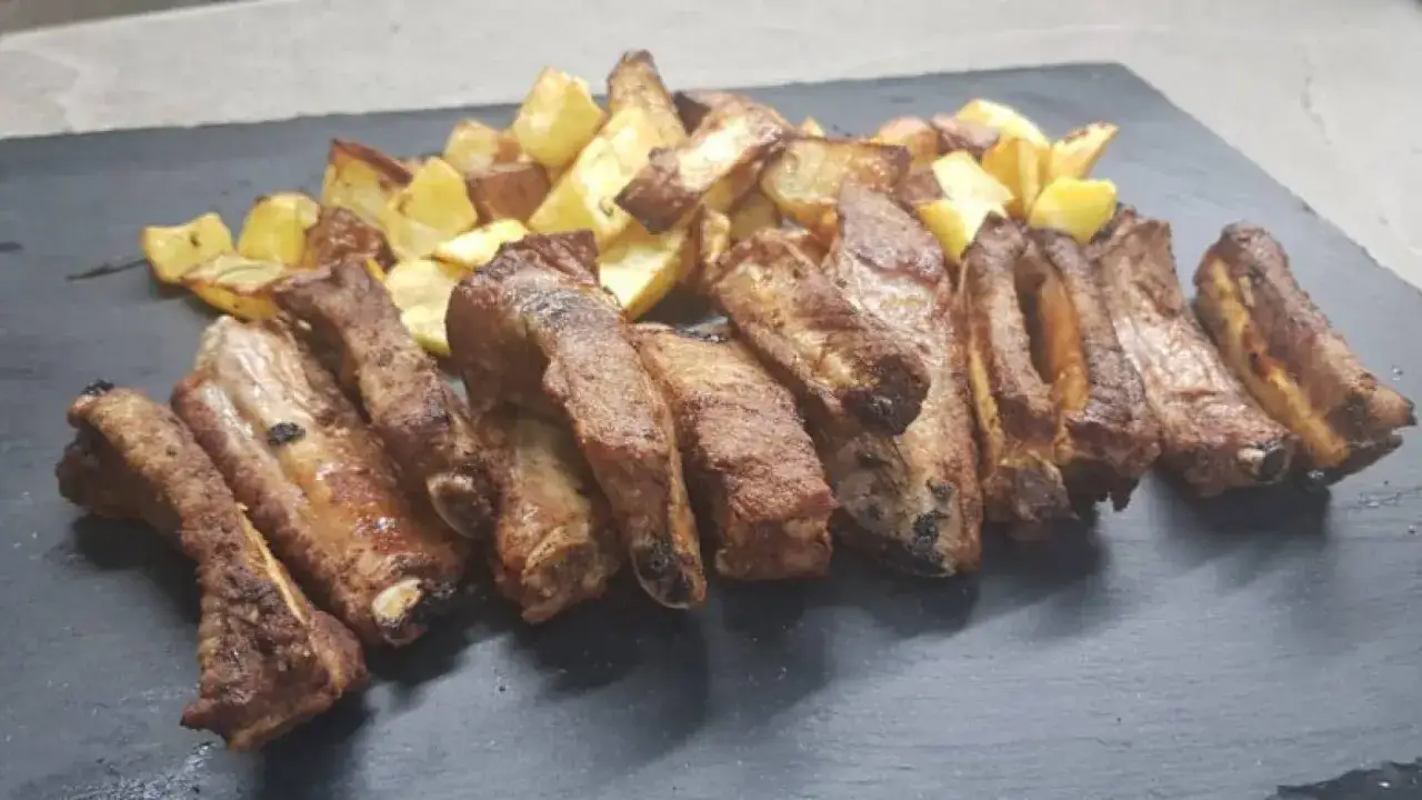 Costine di maiale in friggitrice ad aria, dorate e succulente, servite con patate croccanti. Un piatto perfetto per ogni occasione.