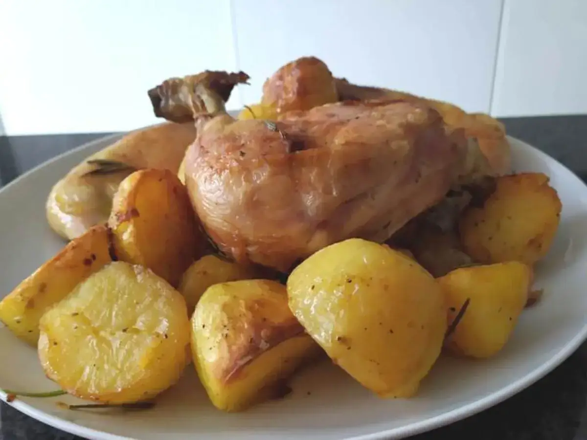 Sovracosce di pollo al forno con patate dorate e profumate, un piatto succulento pronto per essere gustato.