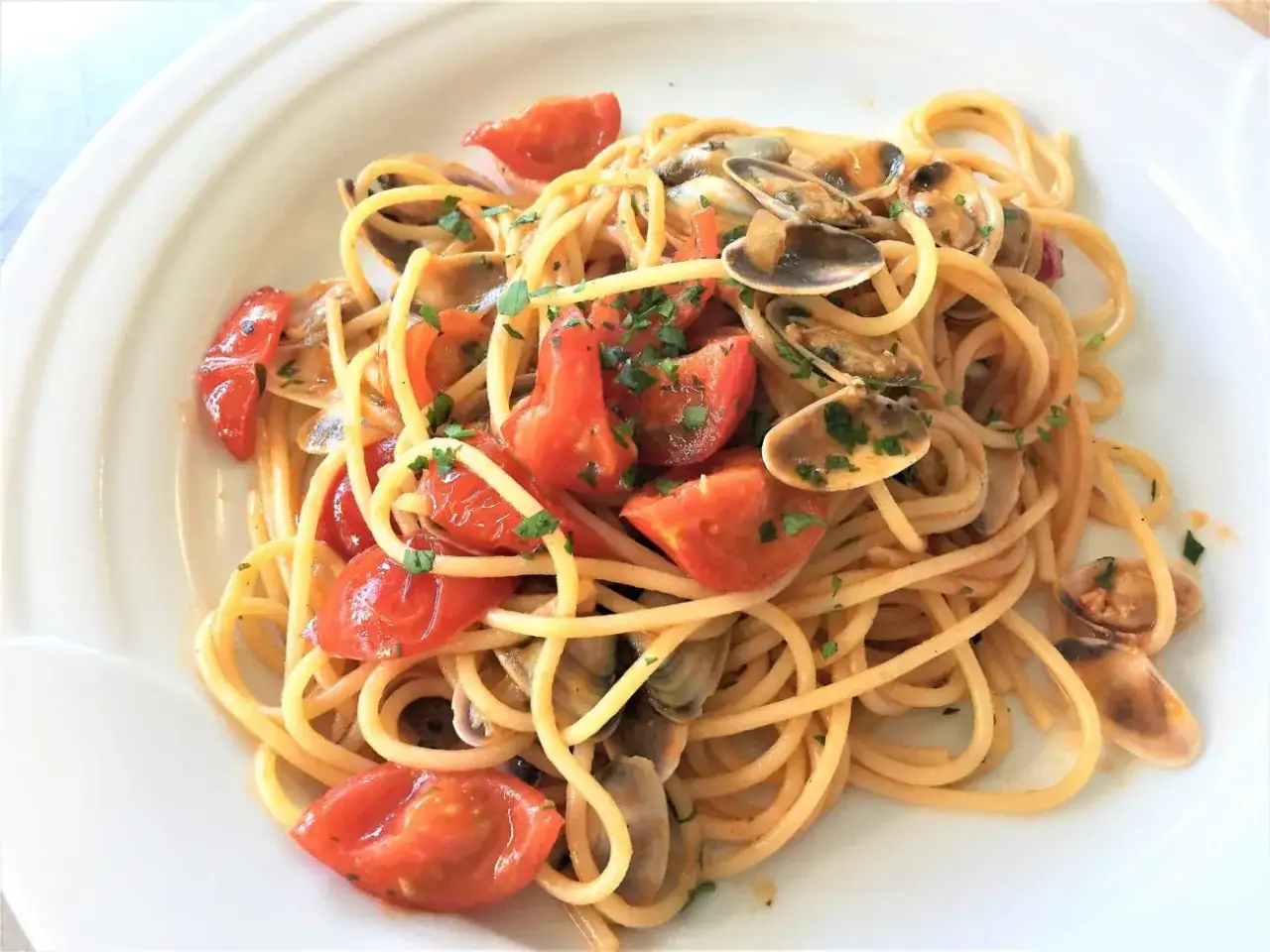 Spaghetti con pomodorini e telline di mare, un piatto estivo profumato e saporito.
