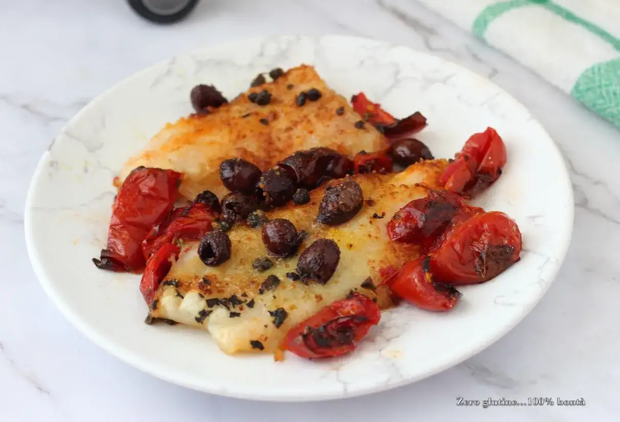 Delizioso merluzzo in friggitrice ad aria, condito con pomodorini confit e olive nere. Un piatto leggero e saporito.
