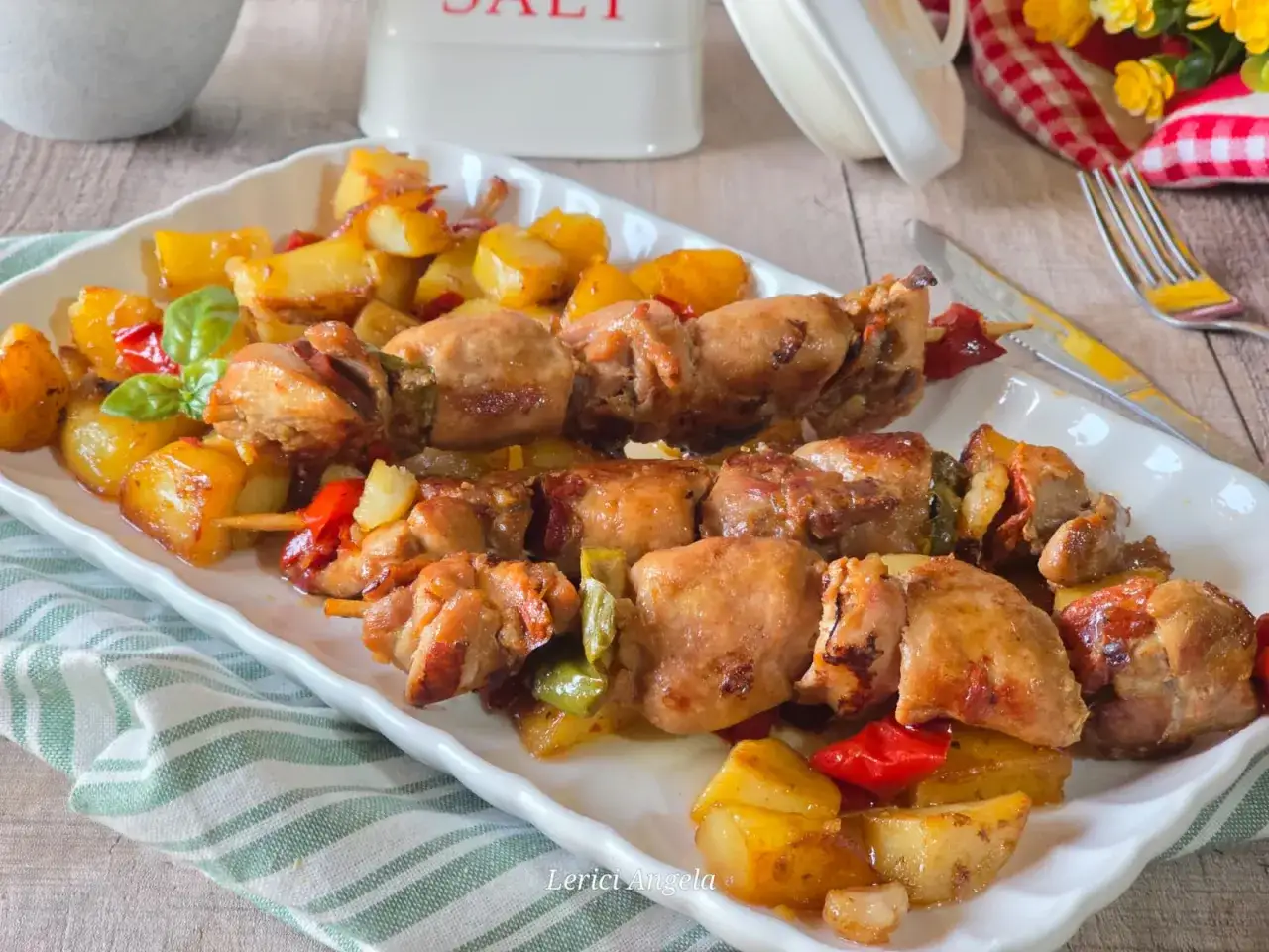 Spiedini di carne succulenti con patate arrosto e peperoni colorati, un piatto invitante e saporito.