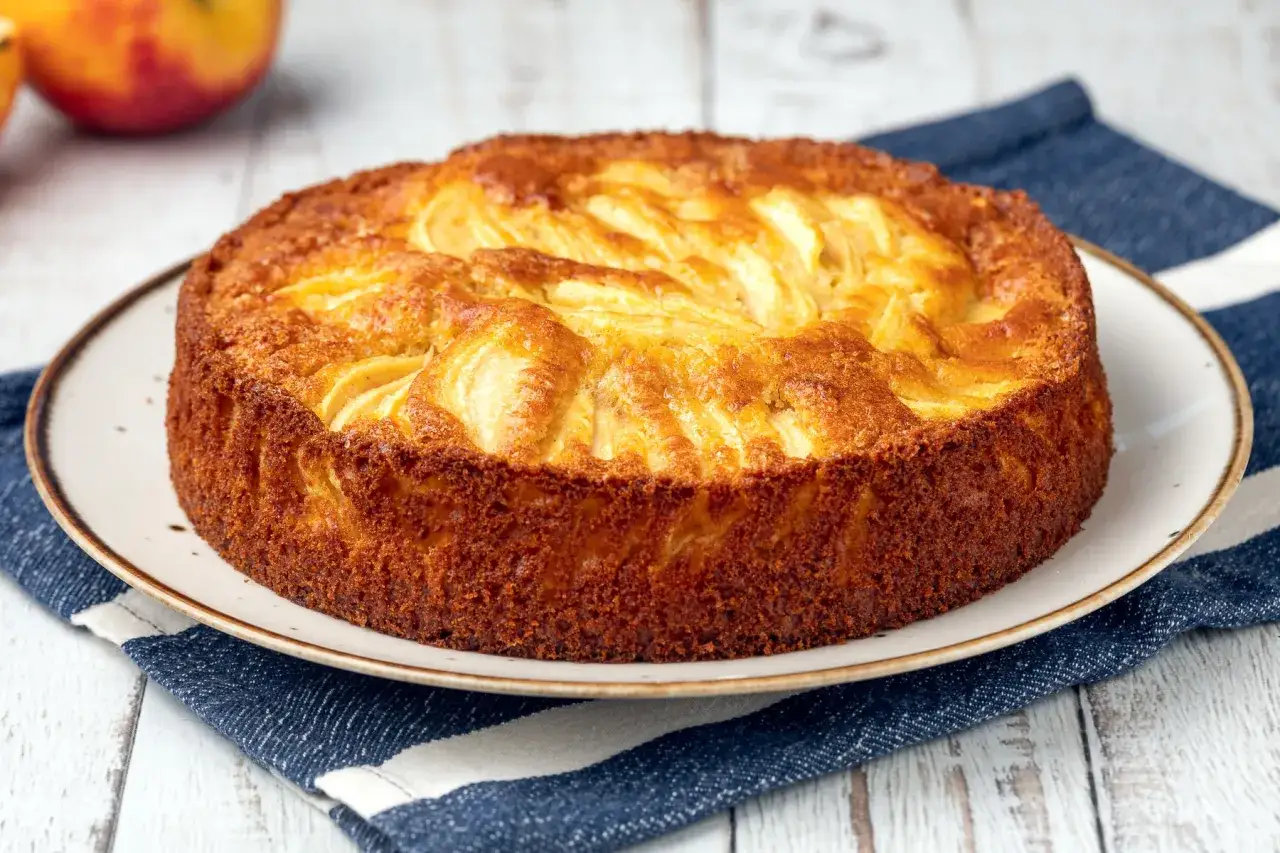 Una deliziosa torta di mele senza glutine, dorata e profumata, pronta per essere gustata.