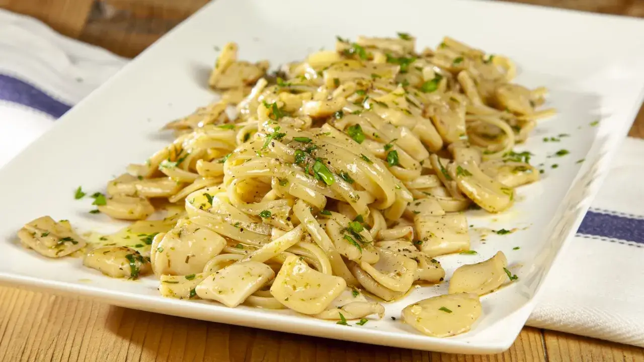 Un piatto invitante di pasta con calamari, condita con erbe fresche e pepe nero, pronta per essere gustata.