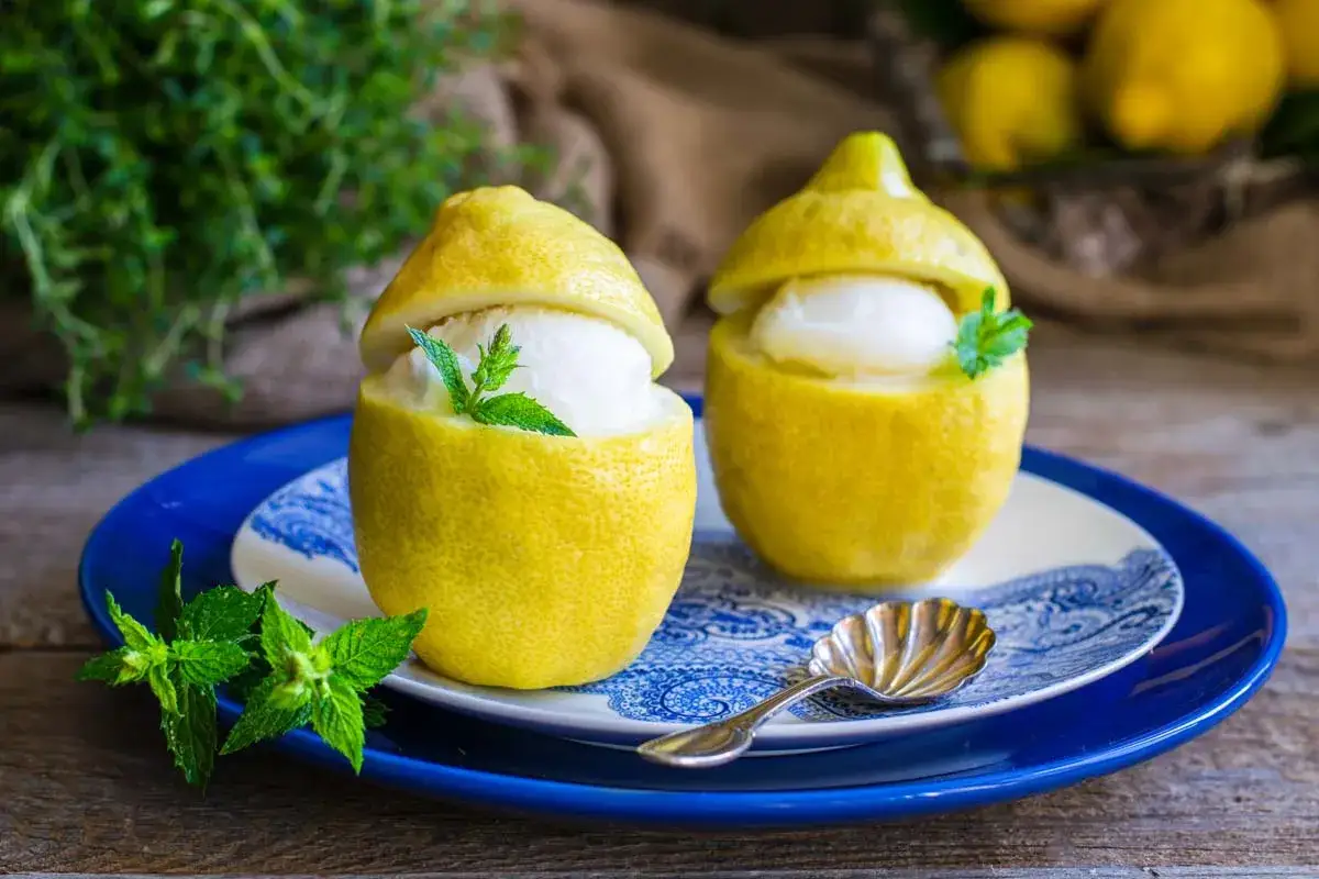 Due deliziosi sorbetti al limone serviti in veri limoni svuotati, guarniti con menta fresca. Un fresco dessert estivo.