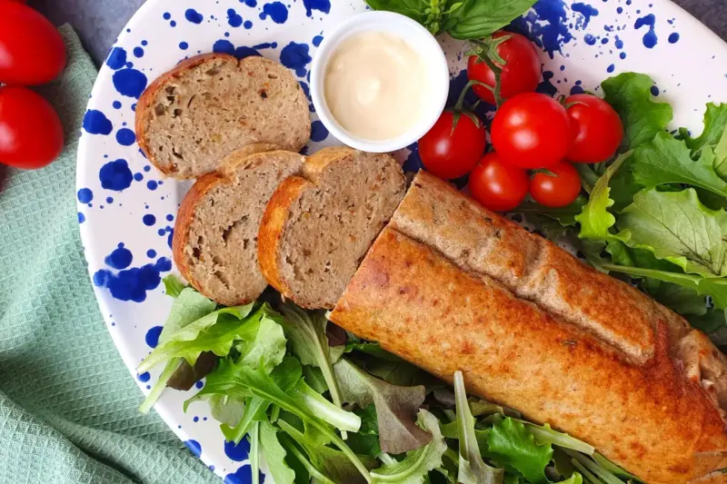 Un gustoso polpettone di tonno affettato, servito con pomodorini, insalata fresca e una ciotolina di maionese.