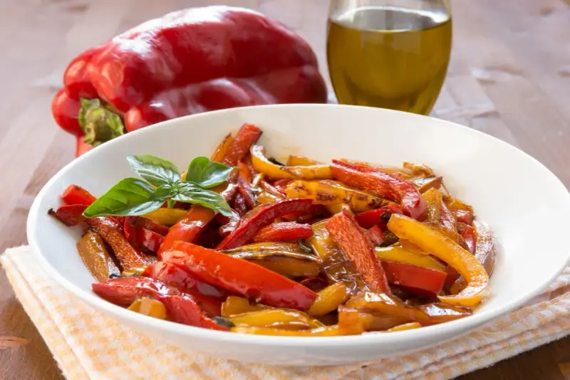 Peperoni in friggitrice ad aria, colorati e succosi, guarniti con basilico fresco.
